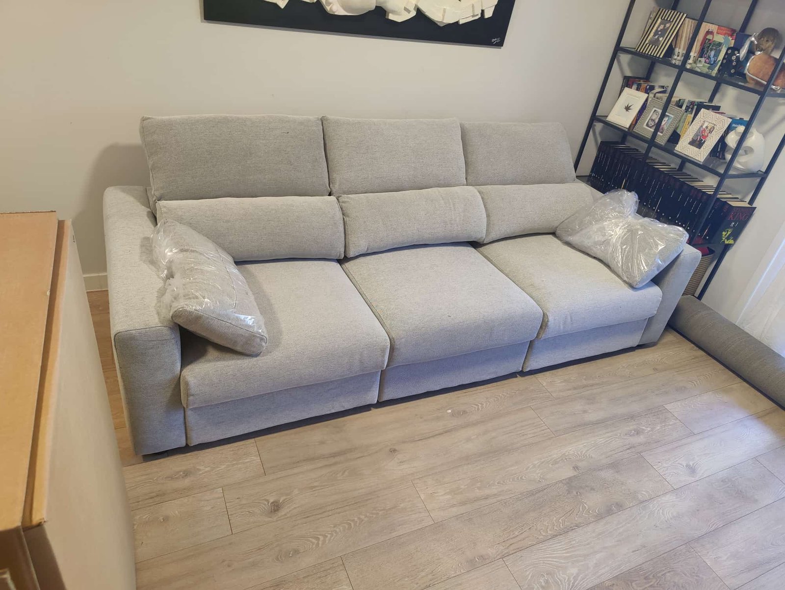 Sofá gris de tres plazas con cojines acolchados