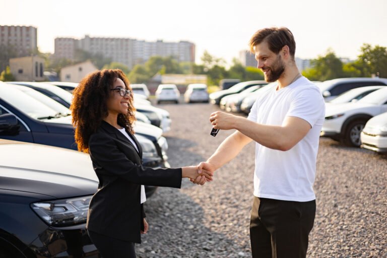 Una vendedora de coches entrega las llaves a un cliente varón